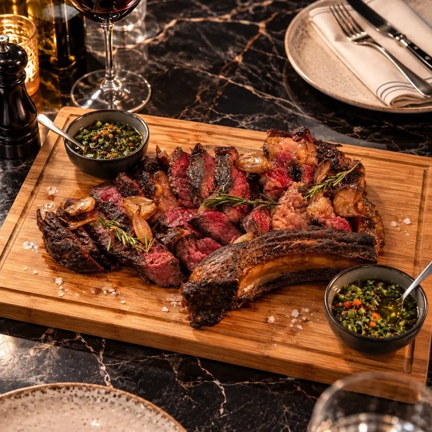 Pièce de bœuf tranchée sur une planche avec ses sauces
