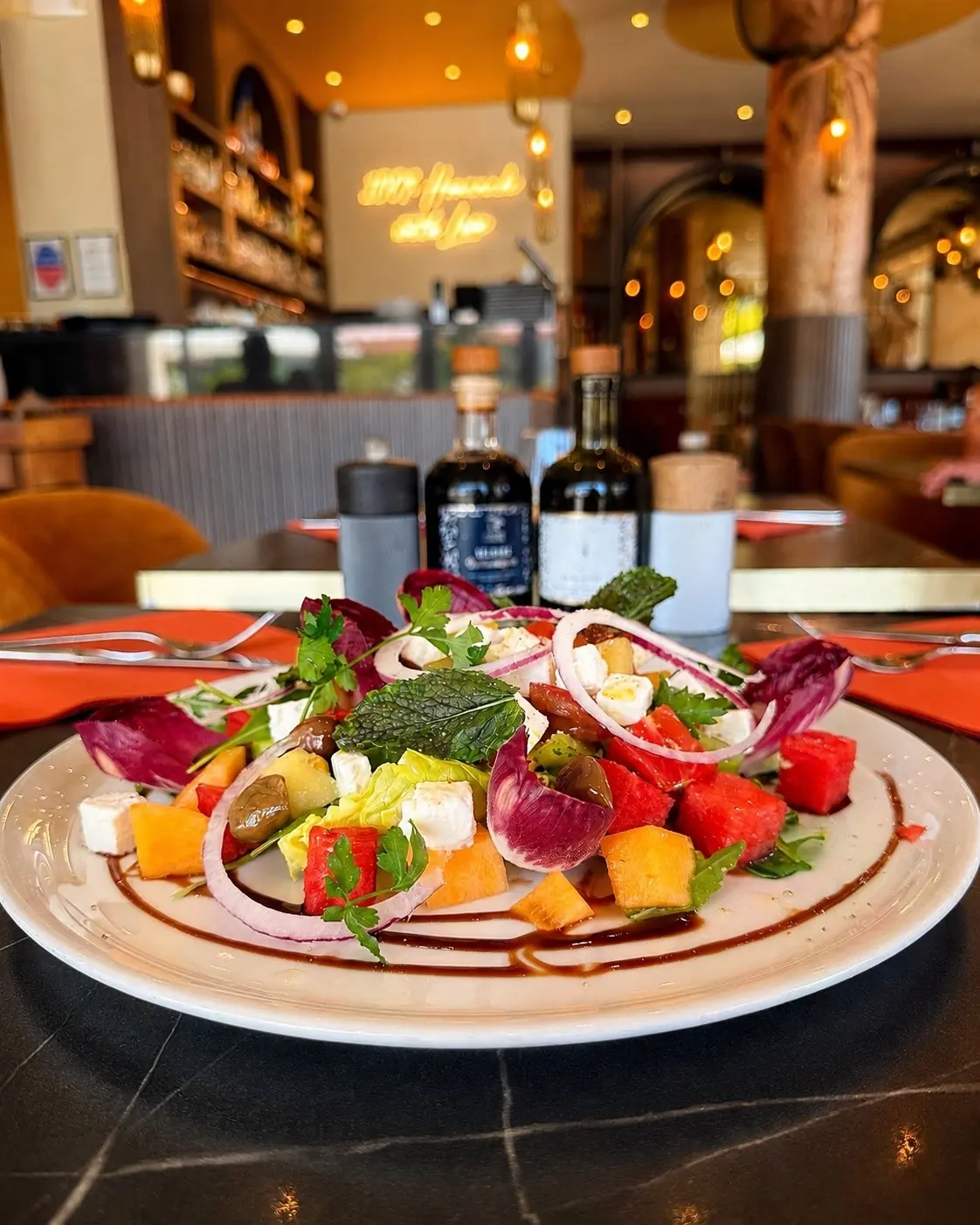 Une salade colorée à la table de La Riviera, dans la lumière chaleureuse du restaurant